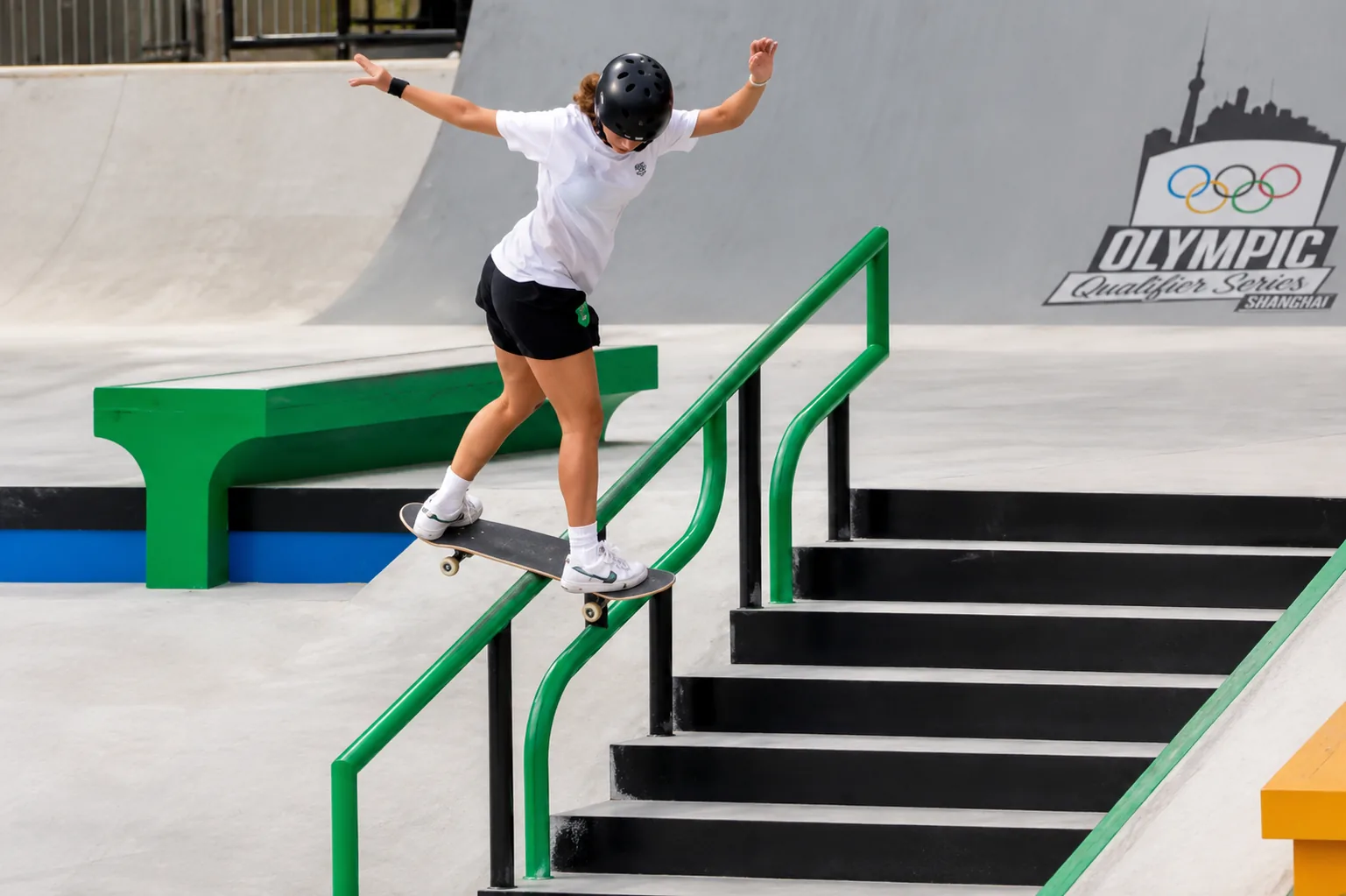 Atleta de skate descendo um corrimão inclinado