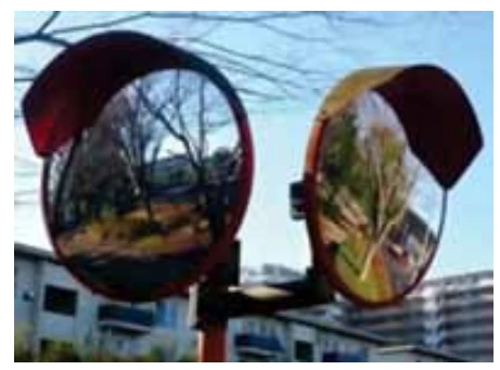 Fotografia de dois espelhos convexos de segurança instalados em um cruzamento.