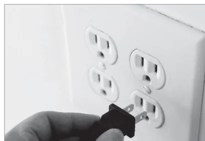 Pessoa conectando um plugue a uma tomada elétrica