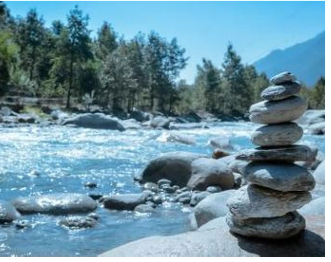 Pedras empilhadas em equilíbrio junto a um rio