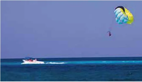 Barco rebocando paraquedista em paraglider sobre o mar