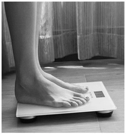 Pés sobre balança inclinada em relação à horizontal.