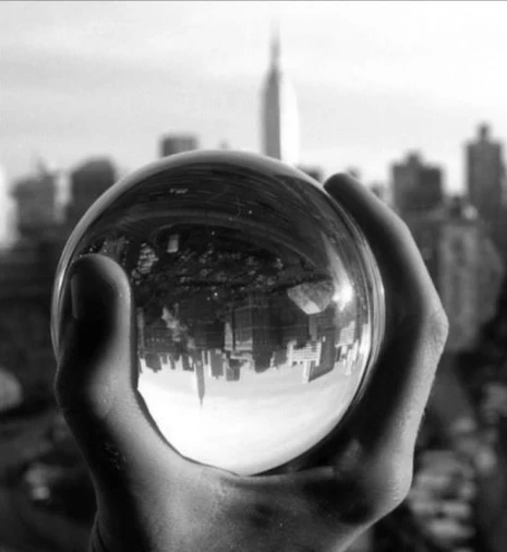 Esfera de vidro mostra imagem invertida da paisagem ao fundo.