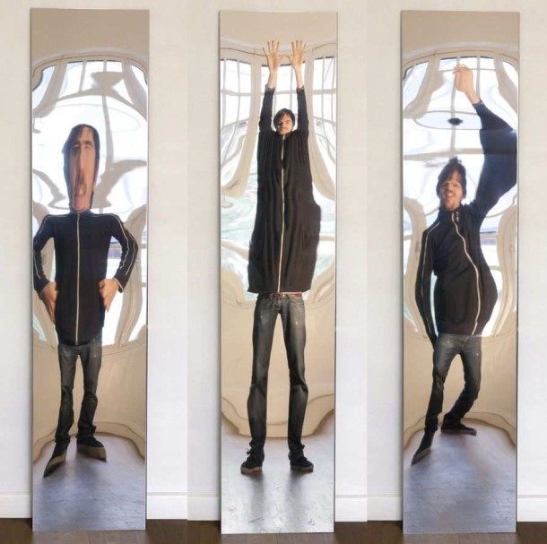 Três reflexos distorcidos de uma mesma pessoa em espelhos curvos de uma casa de espelhos