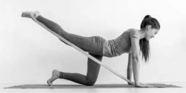 Pessoa realizando exercício com elástico extensor