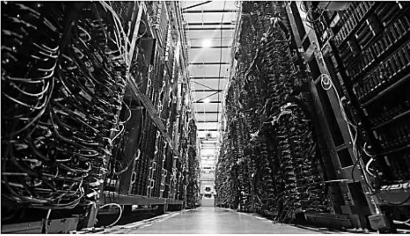 Corredor de um data center com racks de servidores e cabos