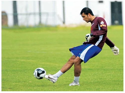 Goleiro chutando uma bola de futebol