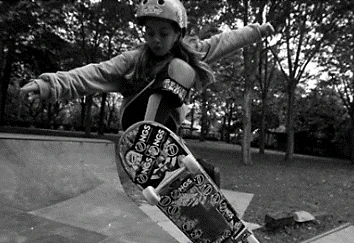 Fotografia de uma criança de capacete andando de skate em uma rampa