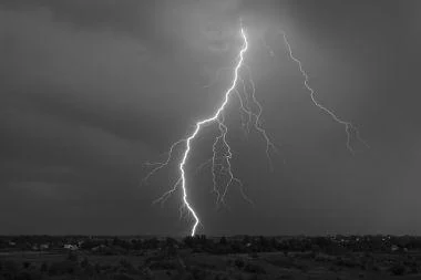 Fotografia de um raio descendo de uma nuvem escura até o solo