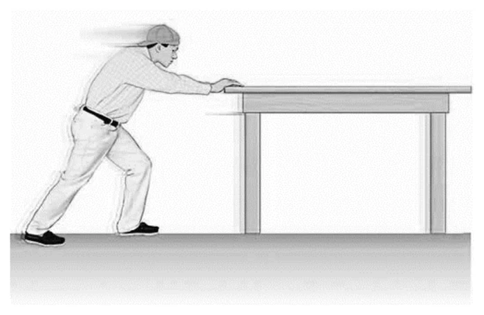 Estudante empurrando uma mesa horizontal