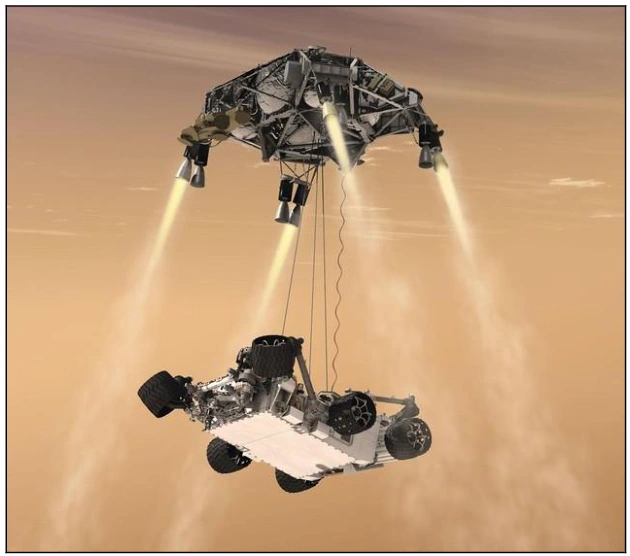 Jipe Curiosity descendo suspenso por cabos de uma plataforma voadora com foguetes.