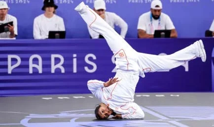 Atleta de breaking executando movimento acrobático nas Olimpíadas de Paris