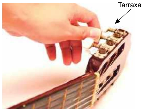 Mão ajustando as tarraxas de um violão