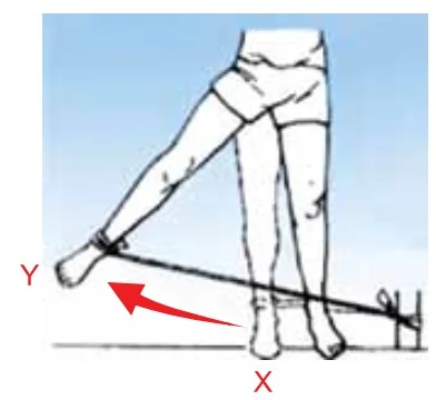 Pessoa em pé fazendo alongamento lateral com a perna presa a uma fita elástica.