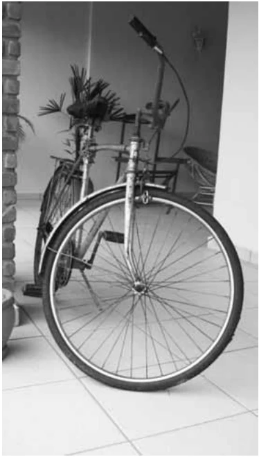 Fotografia de uma bicicleta apoiada no chão, com a roda dianteira em primeiro plano