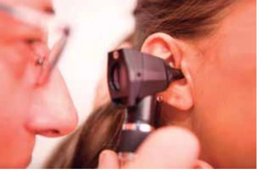 Médico utilizando um otoscópio para examinar a orelha de uma paciente